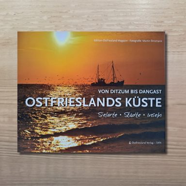 Buchcover mit Sonnenuntergang über dem Meer, einem Fischkutter und Möwen, Titel 'Von Ditzum bis Dangast Ostfrieslands Küste'.